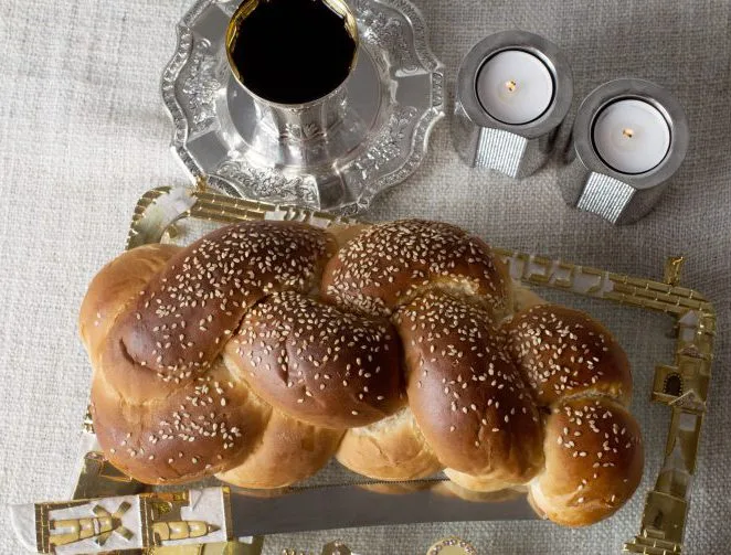Shabbat challah, silver kiddush cup and candles